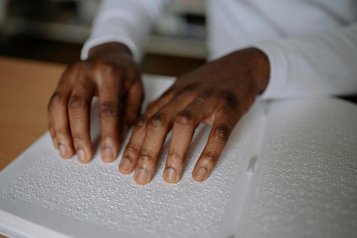 Fingers reading a book in braille