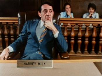 Harvey Milk sitting at a desk in a courtroom