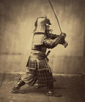 Sepia toned image of a man in samurai armor lunging forward with his sword raised